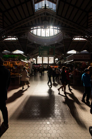 Photographer capturing a modern food market stall with natural light streaming in, showing fresh artisanal goods.