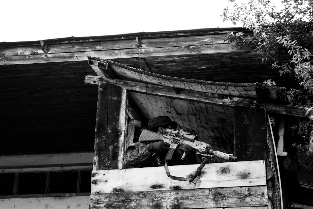 grayscale photo of man in black jacket and pants lying on wooden plank