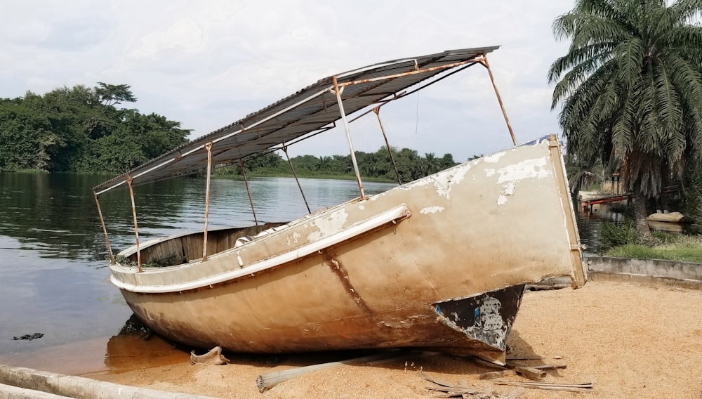 brown and white boat on brown sand during daytime