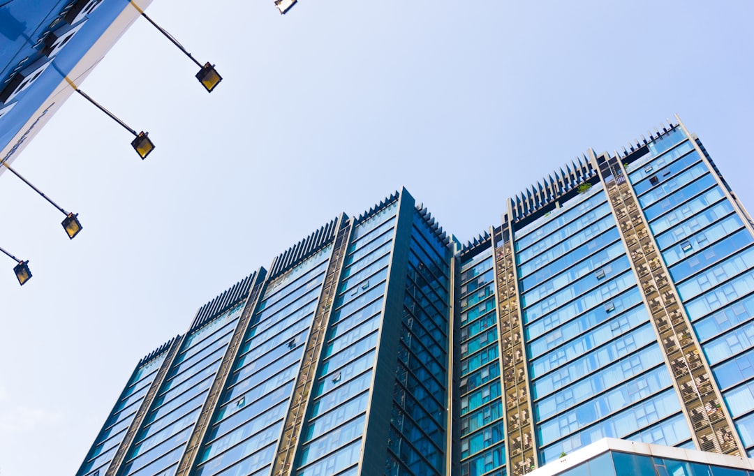 a very tall building with a lot of windows, Glass building on blue sky