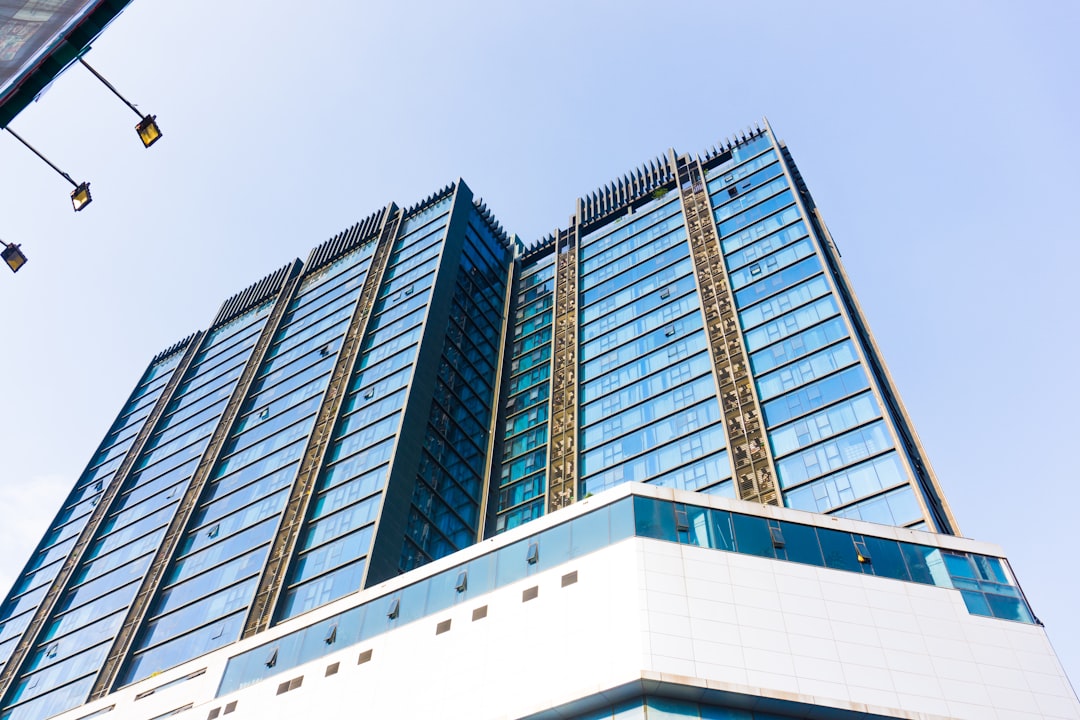 white and black concrete building, Glass building on blue sky