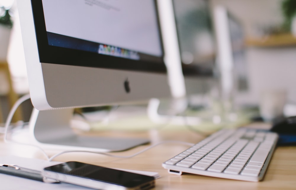 silver imac on brown wooden table