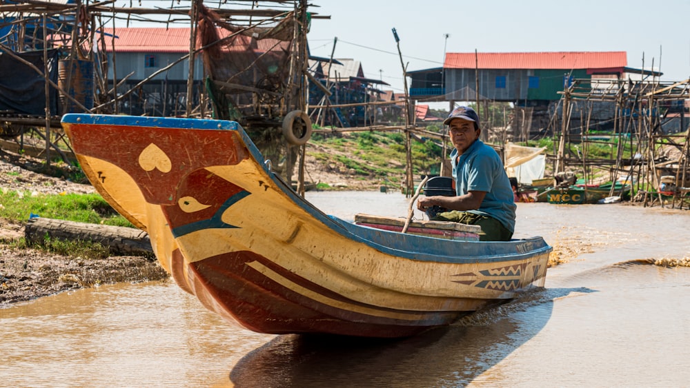 man in white shirt sitting on brown wooden boat during daytime