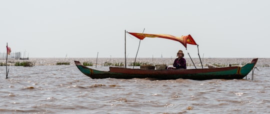 man in black shirt riding on boat during daytime in Siem Reap Province Cambodia