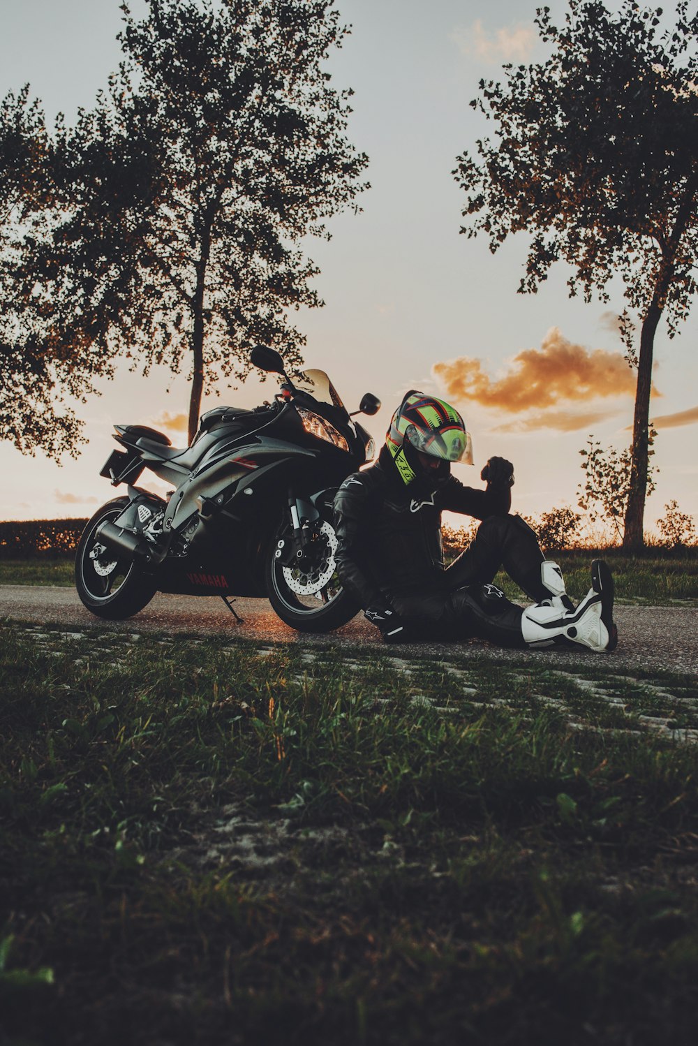 2 men riding sports bike on green grass field during sunset