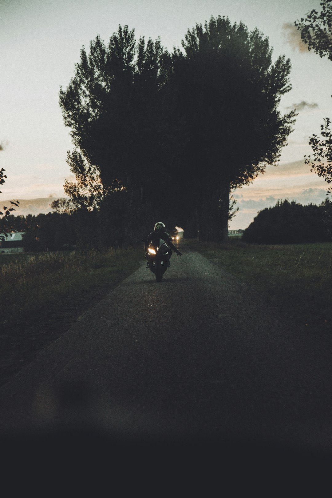 man riding motorcycle on road during sunset