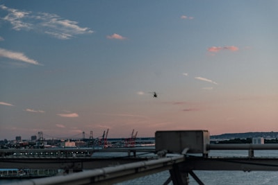 Luxury helicopter flying over the French Riviera coastline at sunset.