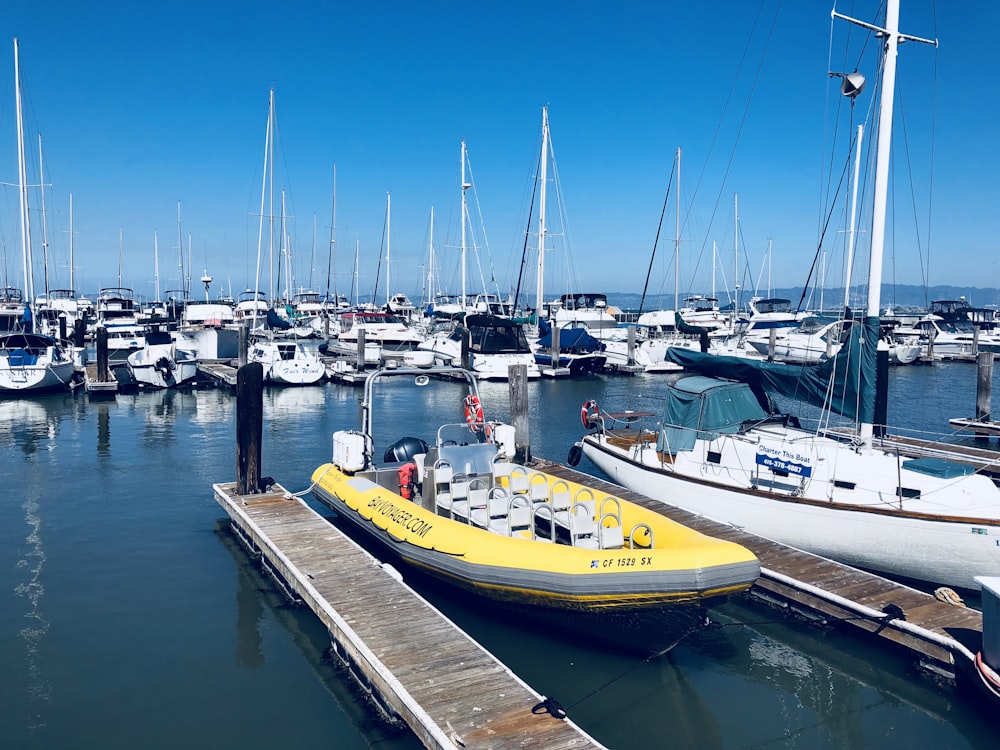 white and yellow boats on dock during daytime
