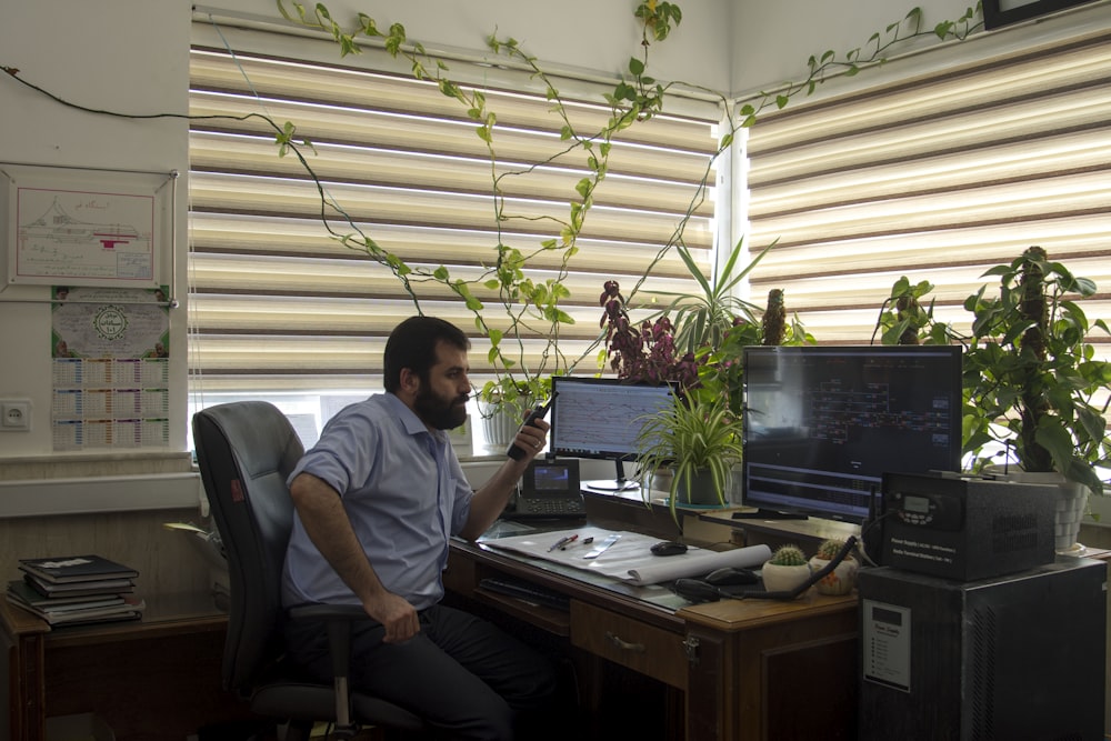 man in gray crew neck t-shirt sitting on black office rolling chair