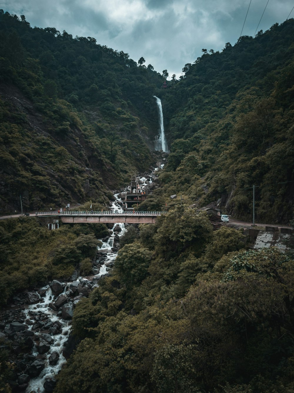 white bridge on green mountain during daytime