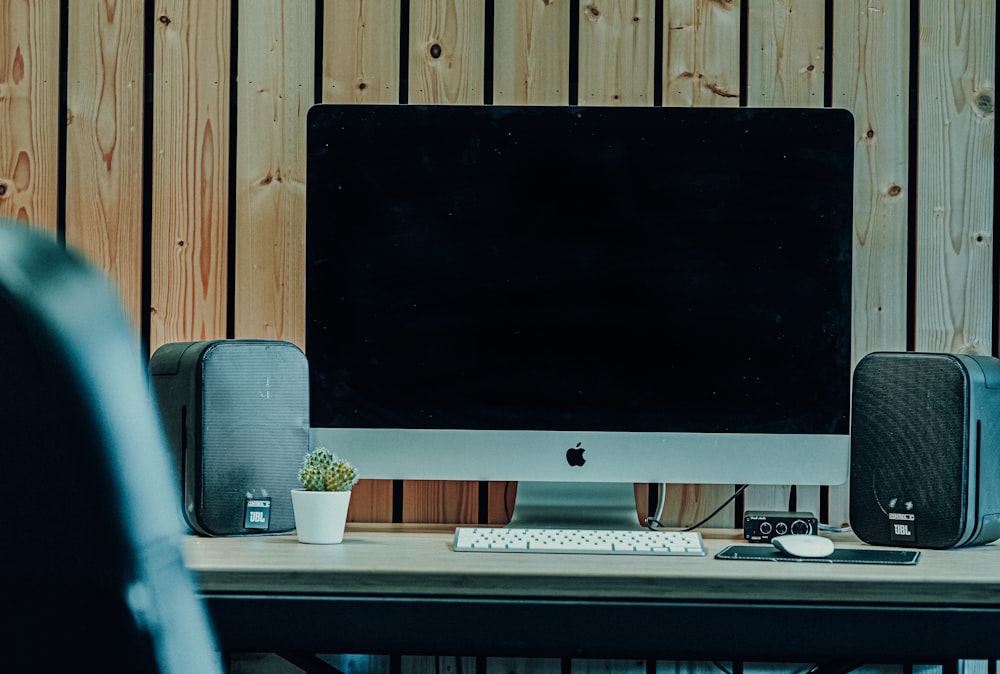 silver imac on white wooden desk