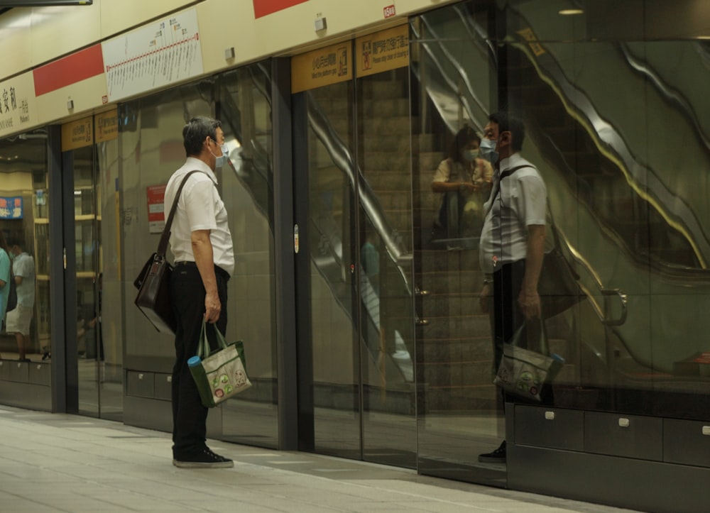 man in white dress shirt and black pants walking on sidewalk