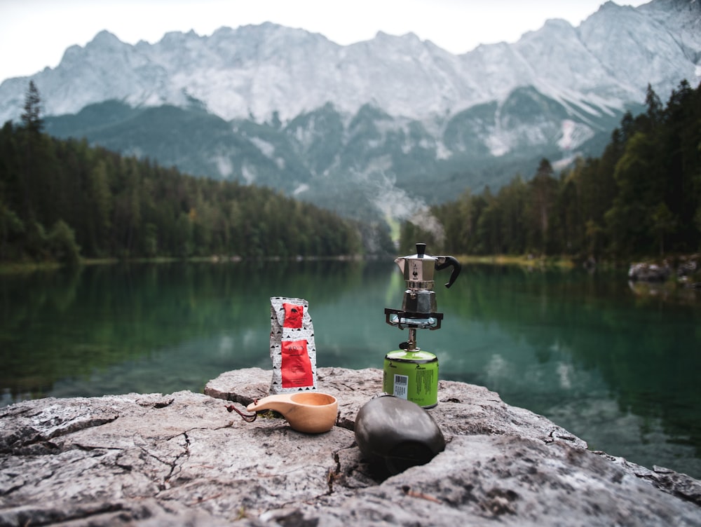 2 clear drinking glasses on brown rock near lake during daytime