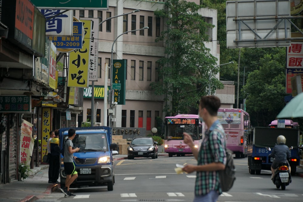 woman in white and pink shirt standing on pedestrian lane during daytime