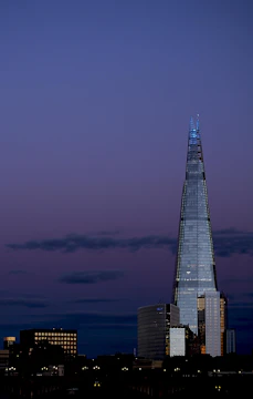 A sleek Manila skyscraper at dusk with soft gold lighting reflecting off the glass.