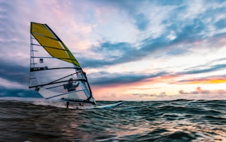 yellow and white sail boat on sea during daytime