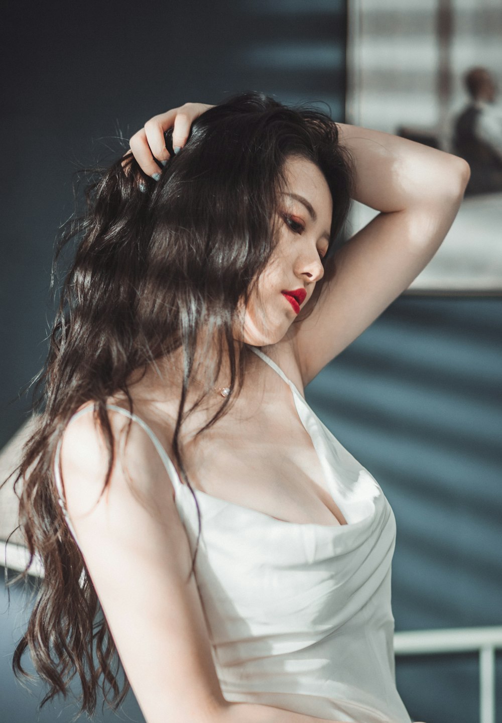 woman in white tank top holding her hair