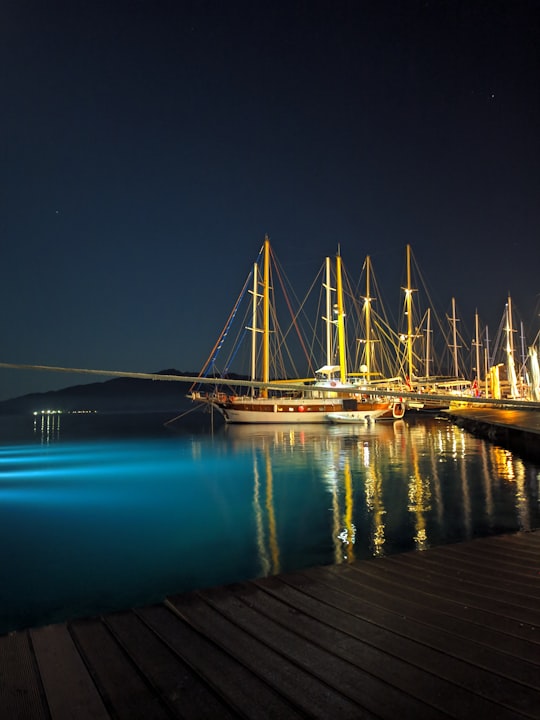 white and brown boat on dock during night time in Marmaris Turkey