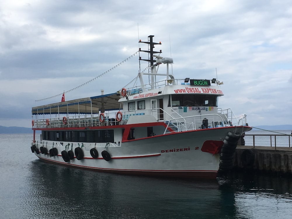 people riding on white and red boat on water during daytime