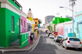cars parked beside green and white concrete building during daytime