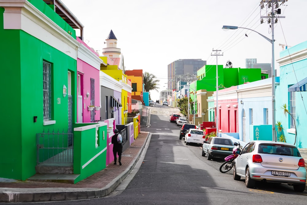 cars parked beside green and white concrete building during daytime