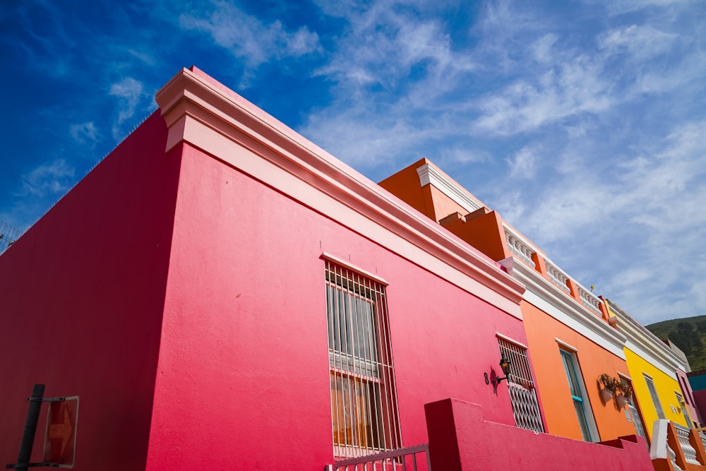 edificio in cemento rosso e bianco sotto il cielo blu durante il giorno