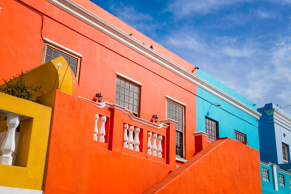 Edificio de hormigón naranja y blanco bajo el cielo azul durante el día