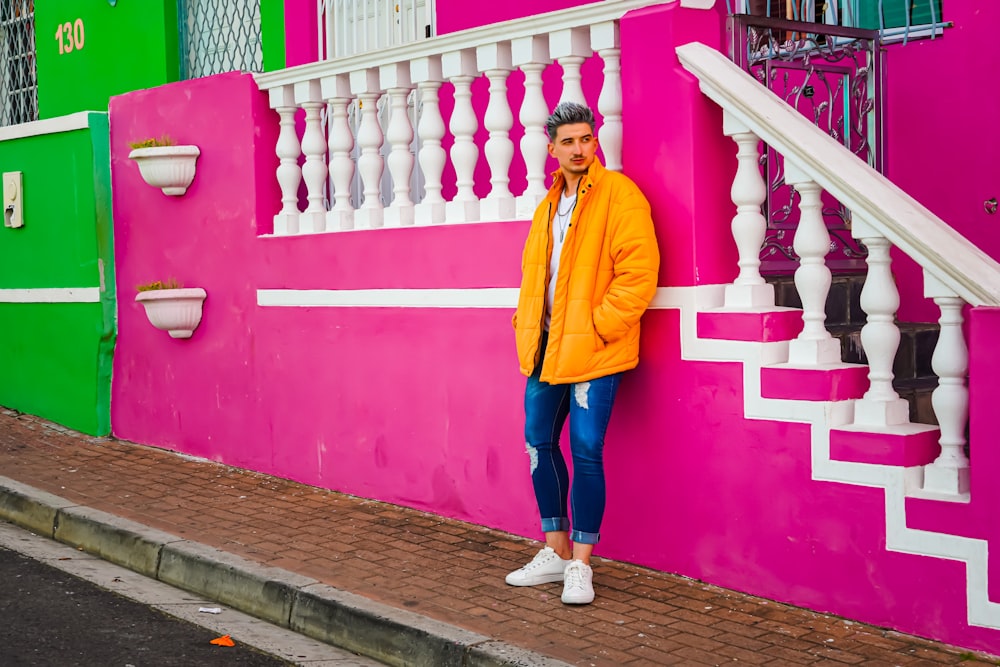 Femme en veste jaune et jean bleu debout sur un chemin en bois brun