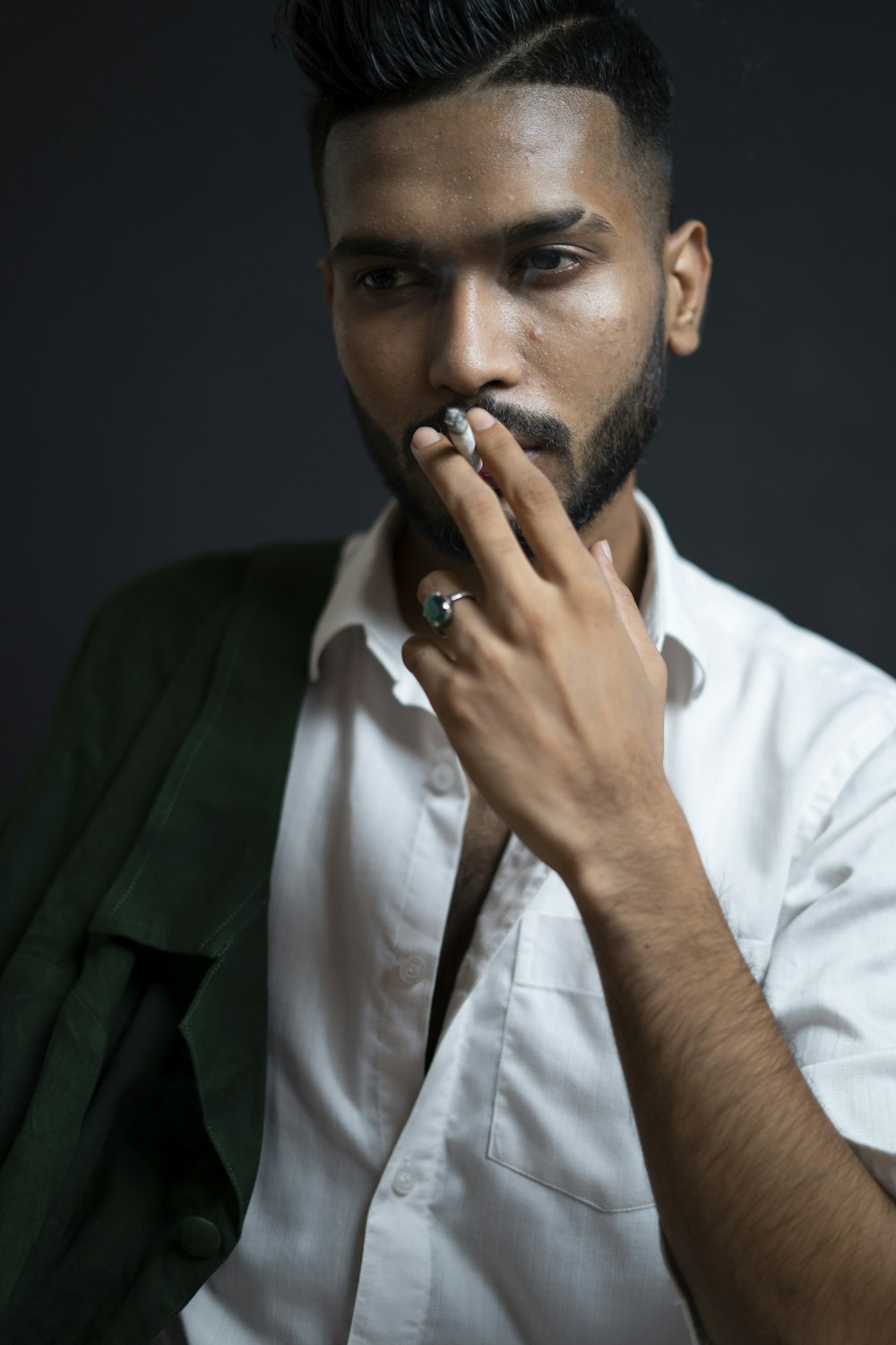 man in white dress shirt holding his face