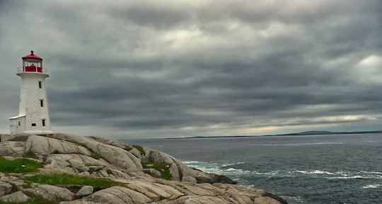 gray rocky shore under gray cloudy sky in Peggy's Point Lighthouse Canada