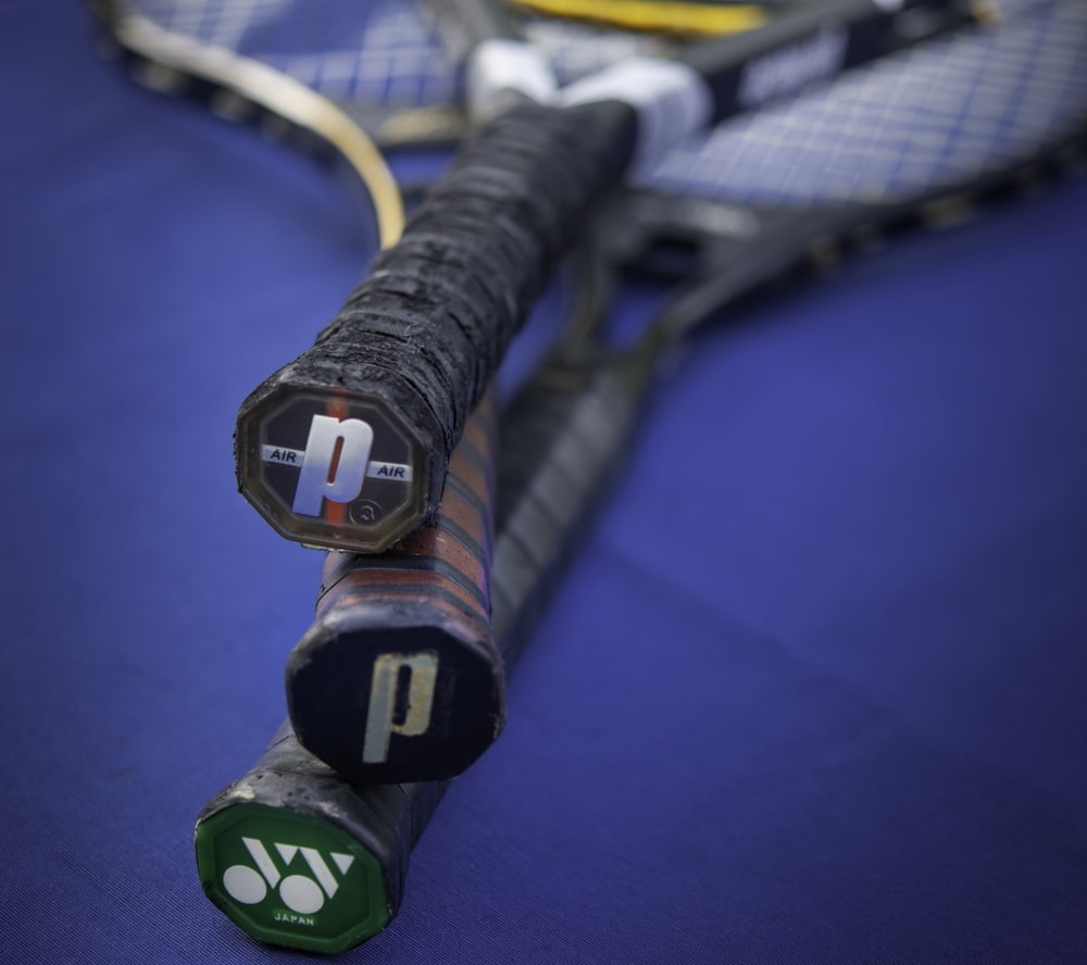 a close up of a tennis racket on a blue surface