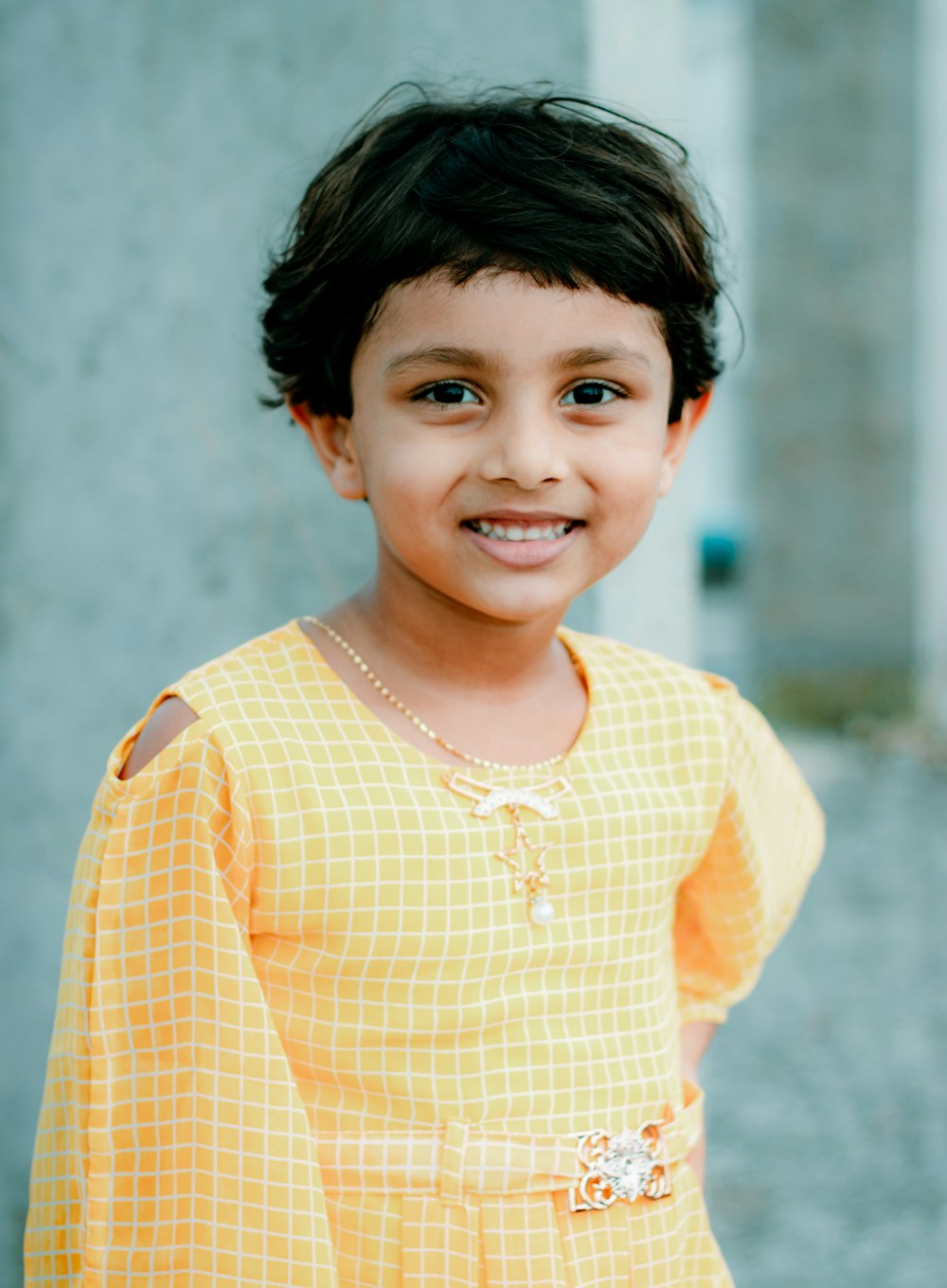 smiling girl in yellow and white checked dress shirt