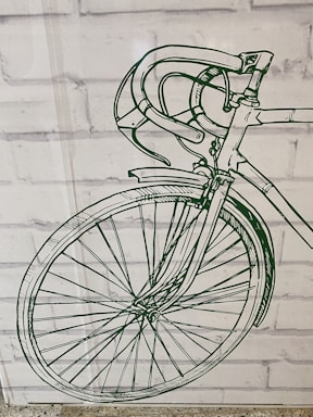 A detailed green line drawing of a bicycle's front half, including the handlebars, wheel, and part of the frame, is displayed against a white brick wall background.