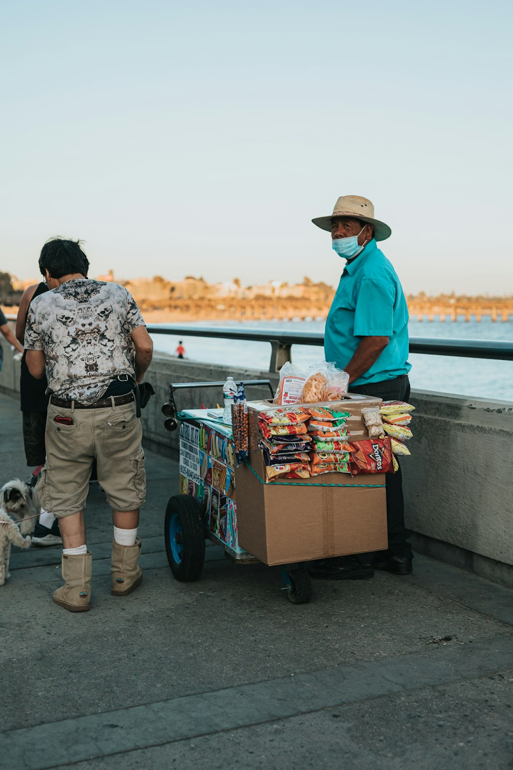 man in blue jacket and brown hat standing beside woman in white and black floral shirt