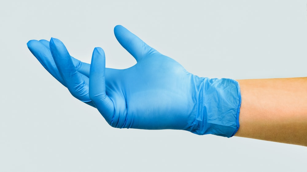 person in blue gloves with white background