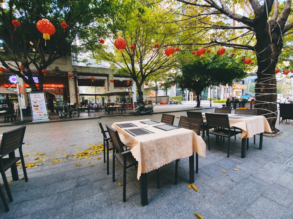 brown wooden table and chairs on sidewalk during daytime