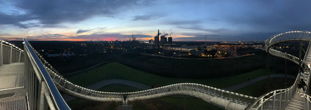 A panoramic view of a large steel bridge under construction at sunset in Latakia.