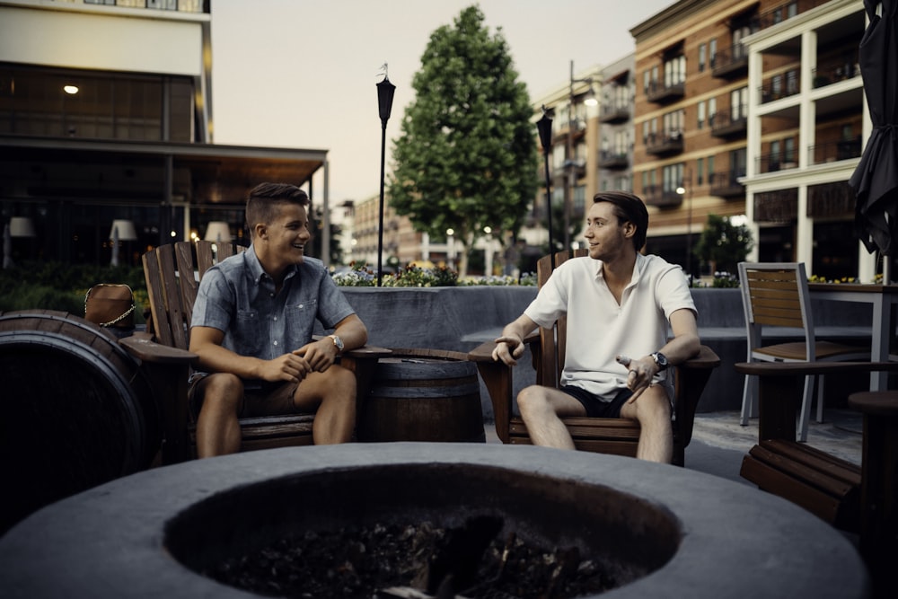 man in white button up shirt sitting beside man in blue dress shirt