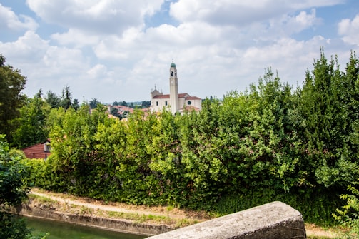 A serene landscape showing a historical building surrounded by greenery, representing heritage preservation.
