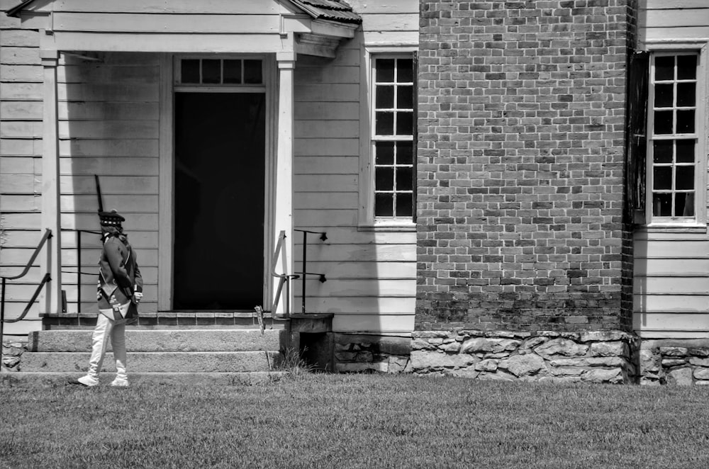 grayscale photo of brick building with glass windows