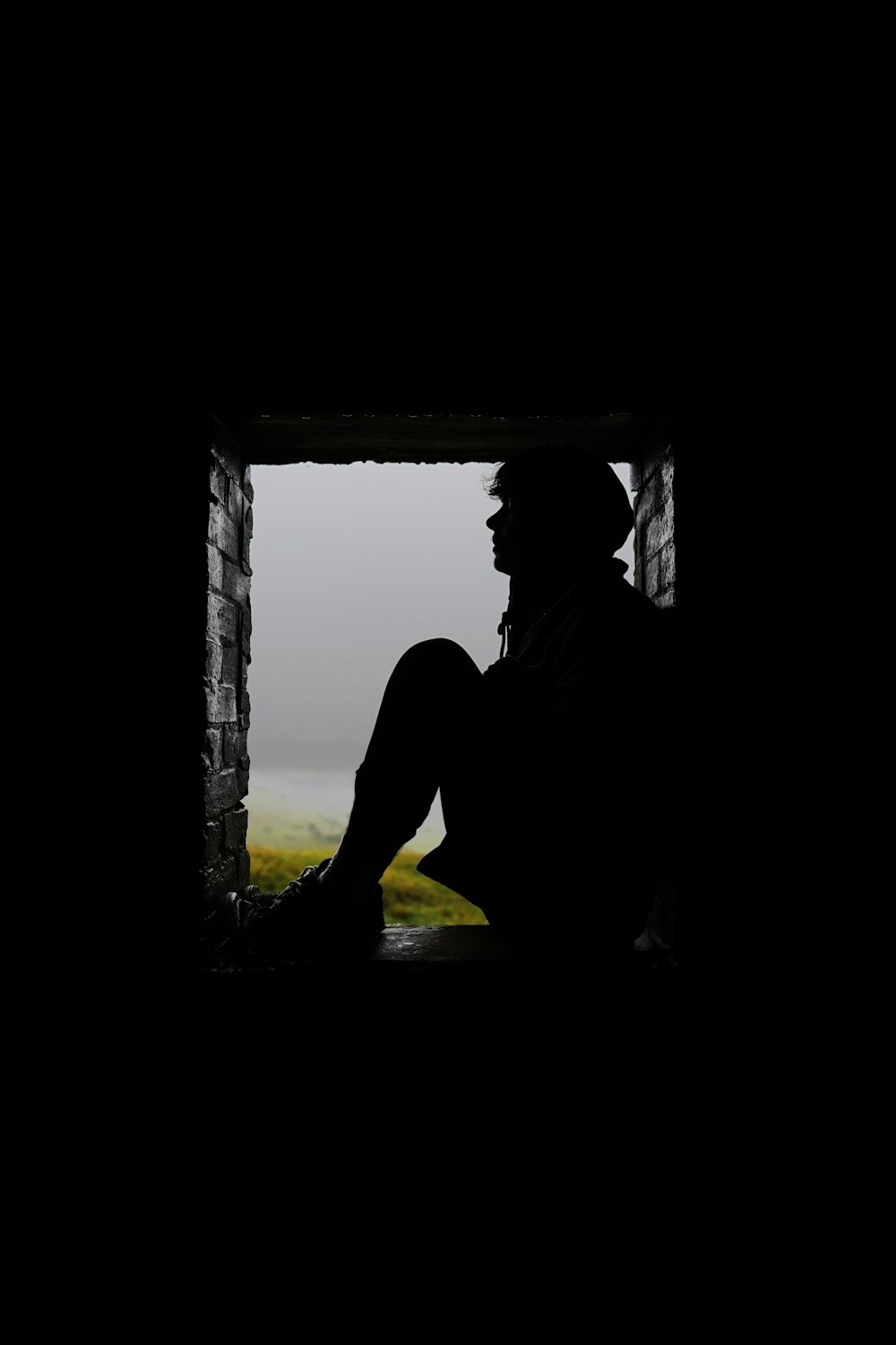 silhouette of man standing near window during daytime