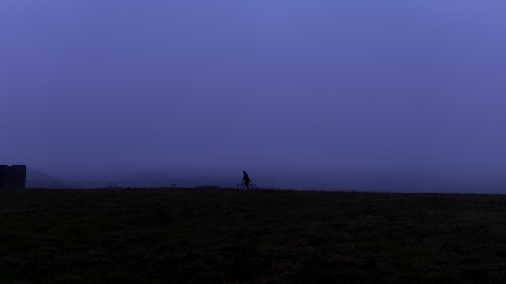 silhouette of person standing on hill during daytime