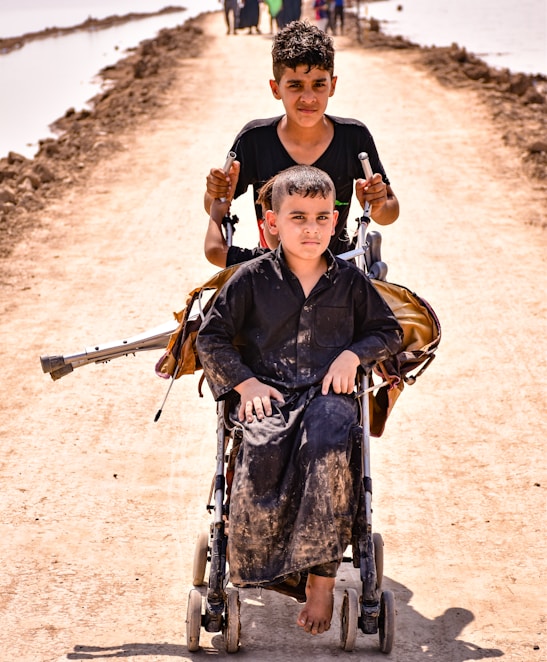 man in black jacket carrying a boy in blue jacket