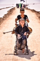 man in black jacket carrying a boy in blue jacket