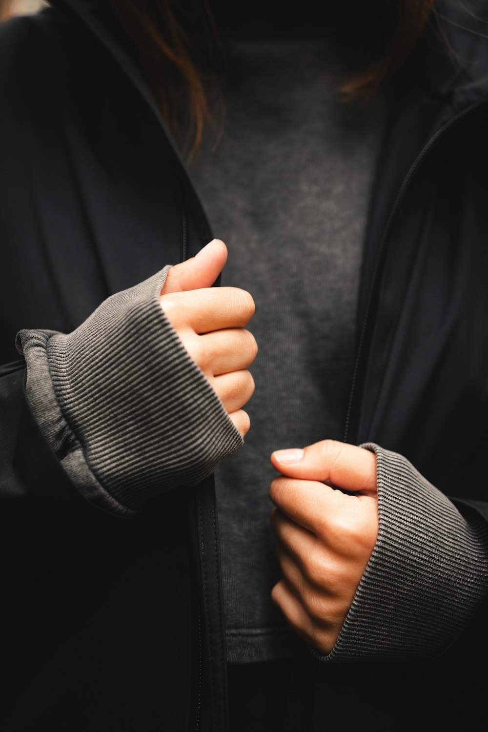 person in black jacket holding persons hand