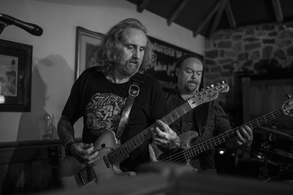 Foto in scala di grigi di un uomo che suona la chitarra