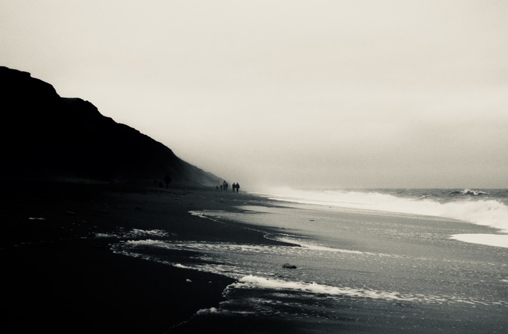 海岸に打ち寄せる海の波のグレースケール写真
