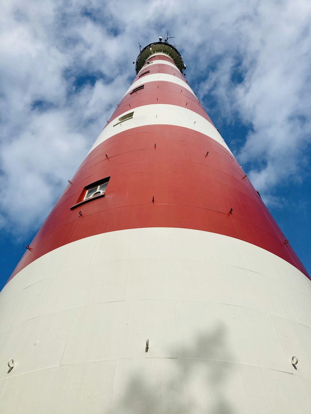 red and white concrete lighthouse under blue sky during daytime