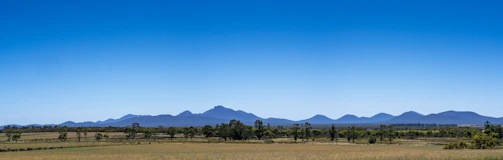 Wide shot of a geophysical survey site with mountains in the background under a clear blue sky.