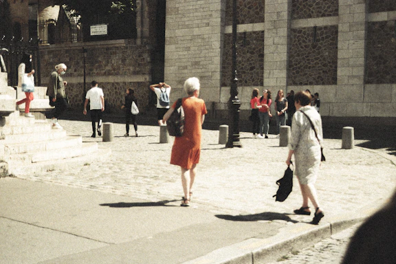 A welcoming community center entrance with people chatting outside on a sunny day.